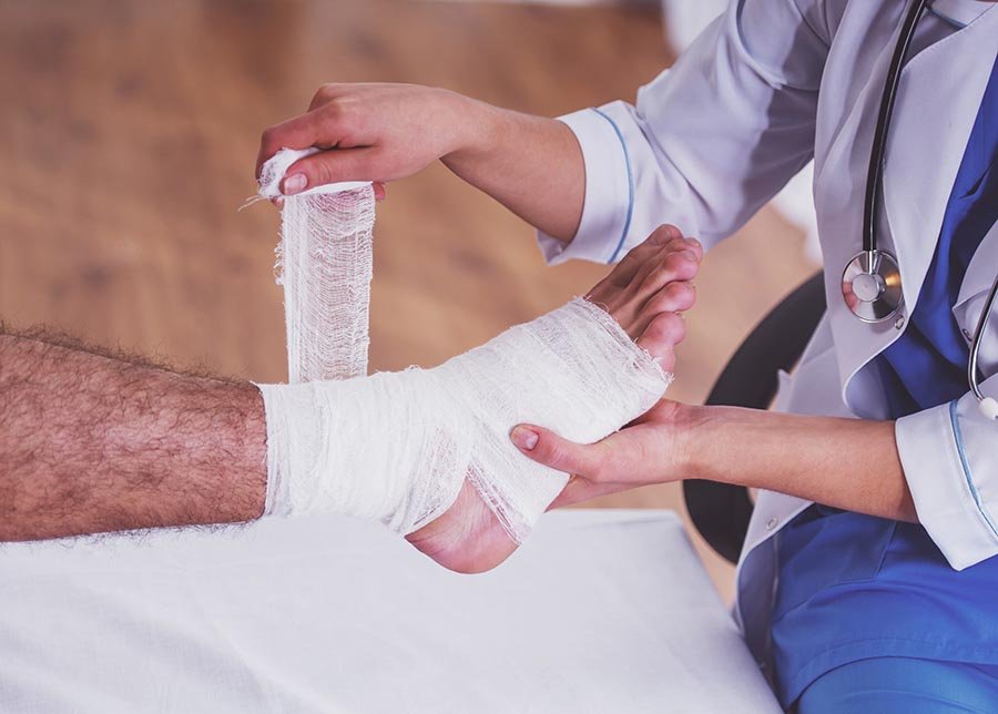 Injury leg. Young man with injured leg. Young woman doctor helps the patient